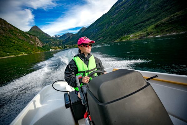 Woman driving a motor boat. Geiranger fjord, Beautiful Nature No