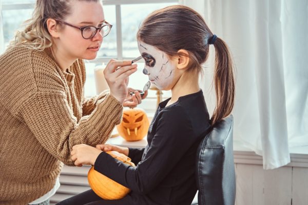 Mom painting daughter face for Halloween party.