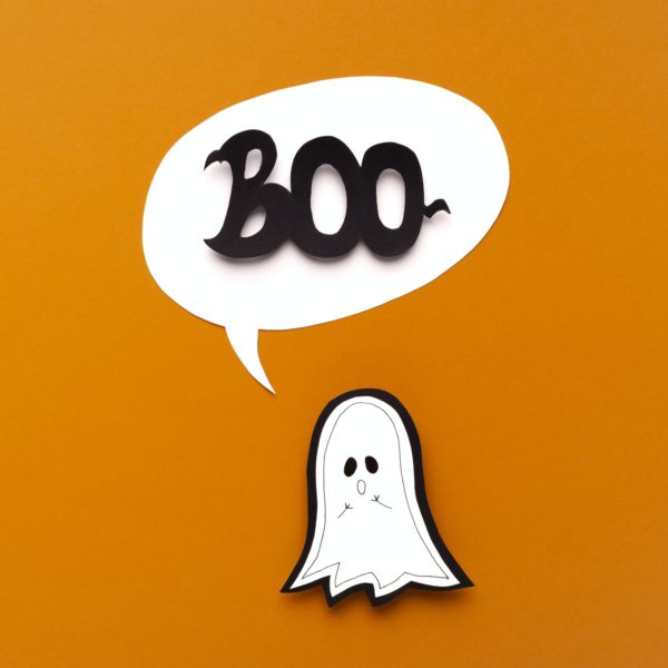 Scary ghost saying boo on orange Halloween background